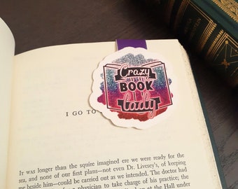 May include: A close-up of a colorful bookmark with glitter and the text "Crazy Book Lady".