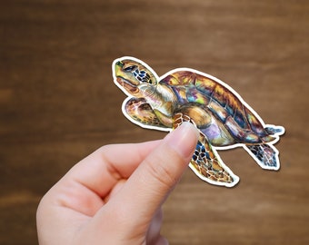 May include: A colorful watercolor sticker of a sea turtle with a brown shell and green, blue, and yellow markings. The turtle is swimming with its head and flippers extended.