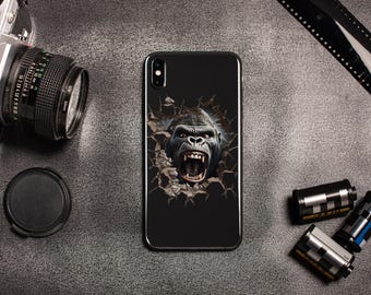 Op de afbeelding: Zwarte smartphonehoes met een gedetailleerde gorilla-afbeelding die door een gebarsten oppervlak breekt. De afbeelding bevat een vintage camera, lensdop en filmcassettes, wat wijst op een fotografiethema.