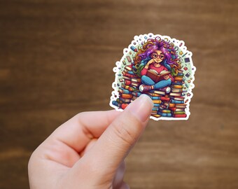 Op de afbeelding: Een kleurrijke sticker met een cartoonmeisje met regenbooghaar dat op een stapel boeken zit en een boek leest. De sticker is omringd door kleurrijke krabbels.