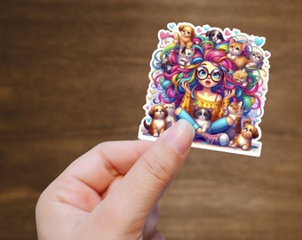 Op de afbeelding: Een kleurrijke sticker met een cartoon illustratie van een meisje omringd door puppy's en kittens. Het meisje heeft regenbooghaar, een bril en draagt een gele trui en een blauwe broek. De sticker heeft een witte rand.