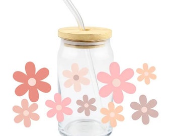 May include: A clear glass drinking cup with a bamboo lid and a curved glass straw. The cup is decorated with pastel-coloured flower decals. The flowers are in shades of pink, peach, and brown.