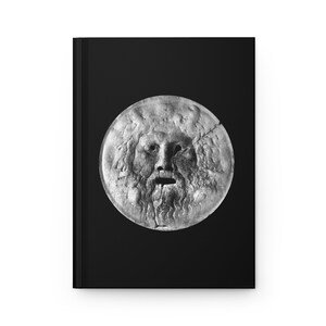 May include: A black and white photograph of a stone sculpture of a face with a large open mouth. The sculpture is round and appears to be a mask.