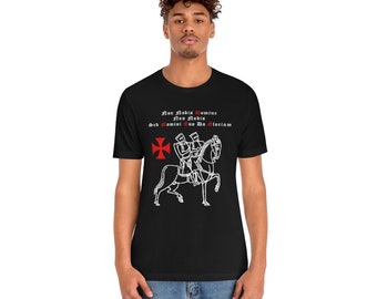 May include: Black t-shirt with a white illustration of two knights on horseback. The knights are wearing armor and carrying swords. The text "Non Nobis Domine Non Nobis Sed Nomini Tuo Da Gloriam" is printed above the illustration.