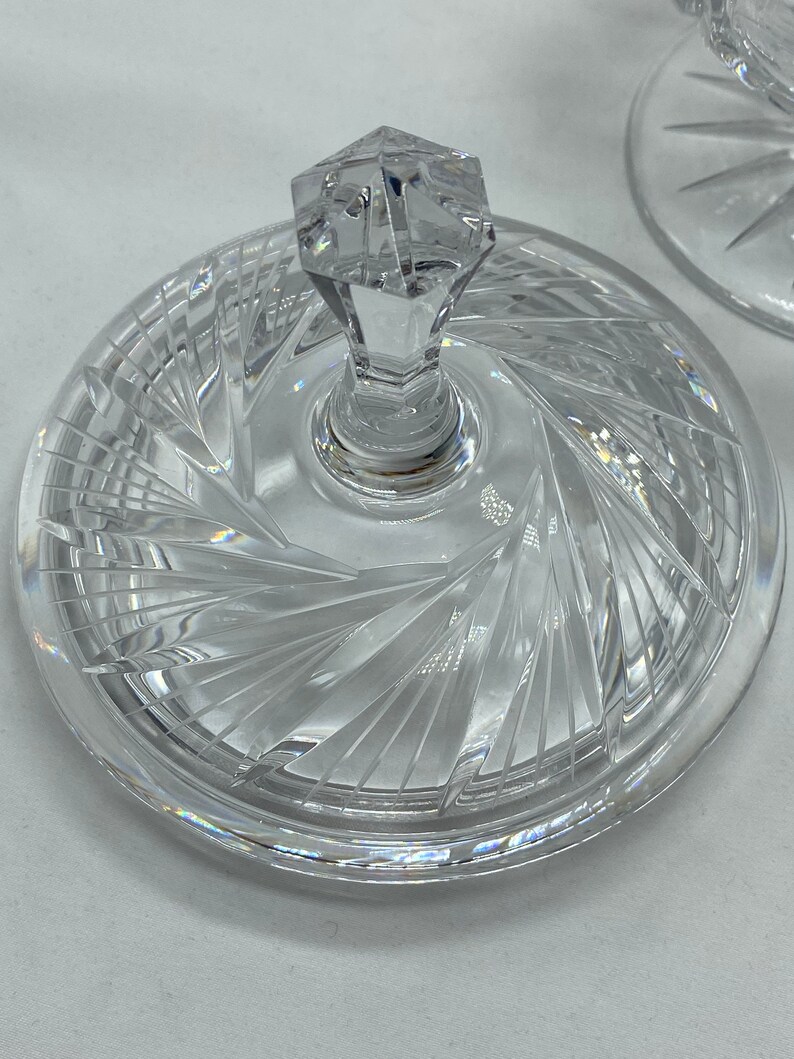 May include: A clear glass lid with a crystal knob and a swirl pattern. The lid is designed for a serving dish or bowl.
