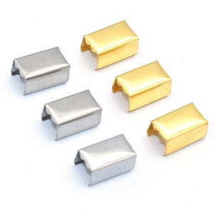 May include: Six metal crimp end findings in gold and silver tones. These small, rectangular findings have a folded design with a curved opening. They are used in jewelry making to secure cords or ribbons.