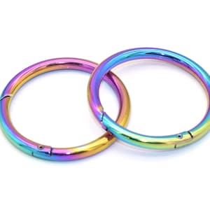 Op de afbeelding: Twee regenboogkleurige metalen sleutelhangers met een veerbelaste sluiting. De sleutelhangers zijn gemaakt van duurzaam metaal en zijn perfect om sleutels, tassen of andere items aan te bevestigen.