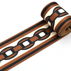 May include: Brown and black striped ribbon with a white chain link pattern.