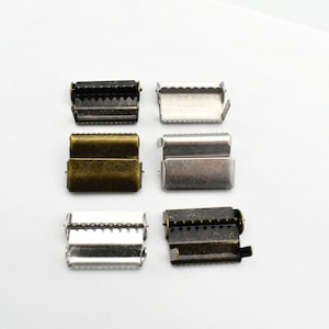 May include: Six metal slider buckles in different finishes: black, antique brass, silver, and antique silver. The buckles are all the same size and shape, with a rectangular design and a serrated edge.