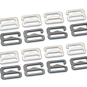May include: A set of 12 silver and black bra strap adjusters. The adjusters are in the shape of an 'S' and have a small triangle on the top.
