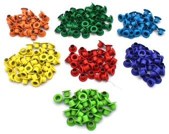May include: Assortment of colorful plastic eyelets in various colors, including orange, yellow, green, red, blue, and light blue. The eyelets are small and round with a hole in the center.