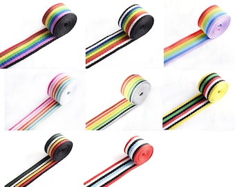 Könnte beinhalten: Sortiment an bunten, gestreiften Bändern, jede Rolle mit einer anderen Farbkombination. Das Band ist etwa 2,5 cm breit und perfekt für Basteln, Nähen und DIY-Projekte.