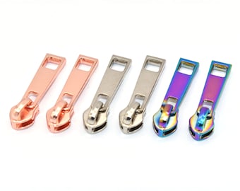 May include: Six zipper pulls in different finishes: two rose gold, two silver, and two iridescent.