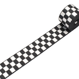 Puede incluir: Cinta de tejido a cuadros en blanco y negro. La cinta está enrollada y el patrón de cuadros es visible.