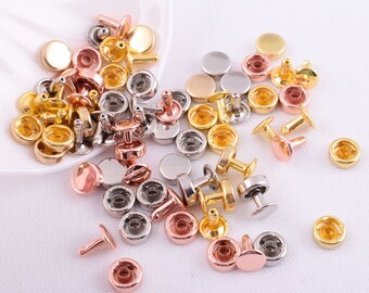 Puede incluir: Surtido de remaches metálicos en colores dorado, plateado y oro rosa. Los remaches son redondos y tienen una cabeza plana con un poste que sobresale del centro. Los remaches se utilizan para sujetar tela, cuero u otros materiales.