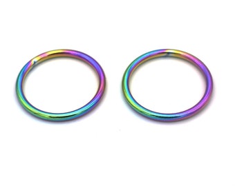 May include: Two rainbow colored metal rings. The rings are smooth and shiny.