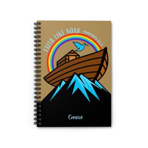 May include: A brown spiral notebook with a tan cover featuring a rainbow, a dove with an olive branch, and a brown ark on top of a mountain. The text "Faith Like Noah Hebrews 11:7" is printed on the cover. The name "Connie" is printed on the black back cover.