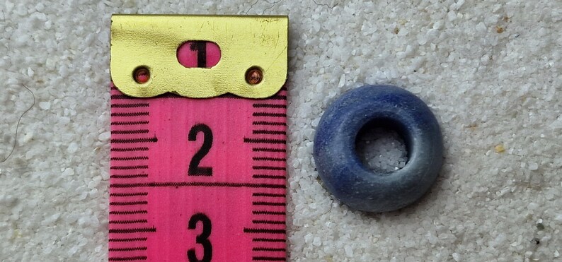 May include: A blue ceramic bead with a hole in the center. The bead is about 1 inch in diameter.