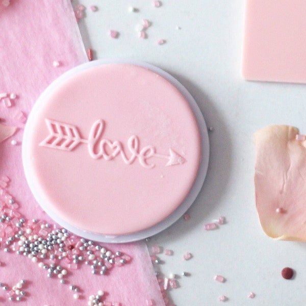 Love inscription with an arrow embosser, cookie biscuit stamp, cake decorating, fondant icing.