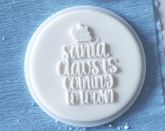 Santa claus is coming to town inscription in leafs embosser, cookie biscuit stamp, cake decorating, fondant icing.