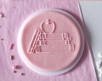 Books with an apple embosser, cookie biscuit stamp, cake decorating, fondant icing.