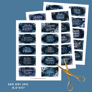 May include: A printable sheet of rectangular Christmas-themed gift tags featuring dark blue backgrounds, white calligraphy text, and floral accents. The text includes phrases like Deck the Halls, Merry Christmas, and Bright Blessings. Gold scissors are included.