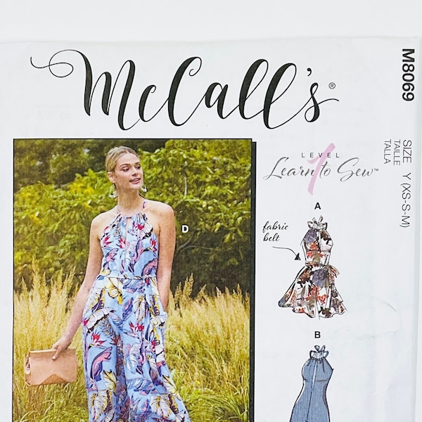 May include: A sewing pattern for a jumpsuit with a halter neckline and wide legs. The pattern is from McCall's and is part of their "Learn to Sew" series. The pattern includes instructions for making a fabric belt and a stitched hem.