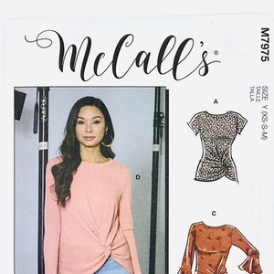 May include: A sewing pattern for a women's top with multiple view options. The pattern includes instructions for making a long-sleeved top with a twist detail, a short-sleeved top with a leopard print, and a long-sleeved top with a ruffled sleeve. The pattern is from McCall's and is size Y (XS-S-M).