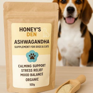 May include: A brown paper bag of Honey's Den Ashwagandha supplement for dogs and cats. The label includes the text "Calming Support, Stress Relief, Mood Balance, Organic, 100g". A wooden scoop holds the supplement, and a dog is in the background.