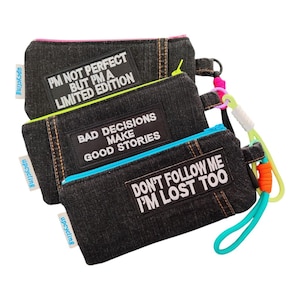 Könnte beinhalten: Drei Jeans-Reißverschlusstaschen mit farbigen Akzenten. Jede Tasche hat ein gesticktes Zitat: "I'M NOT PERFECT BUT I'M A LIMITED EDITION", "BAD DECISIONS MAKE GOOD STORIES" und "DON'T FOLLOW ME I'M LOST TOO".