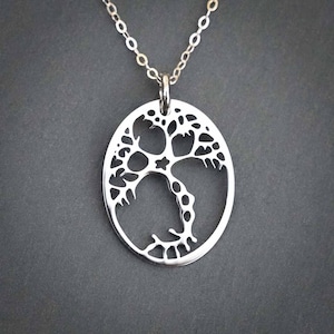 May include: A silver necklace with a circular pendant featuring a detailed tree of life design.