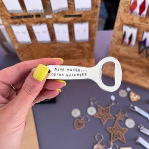 May include: Silver bottle opener keychain with the text "Save Water... Drink Guinness".