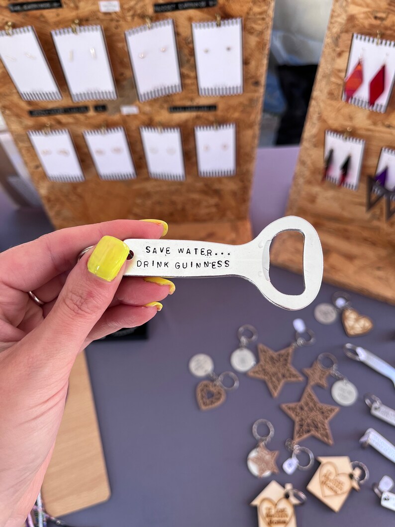 May include: Silver bottle opener keychain with the text "Save Water... Drink Guinness".
