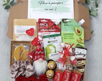 May include: A gift box filled with self-care items, including bath salts, face masks, chocolates, and cookies. The box includes a card that says "Have a pamper on me :)".