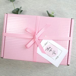 May include: A pink gift box with a white ribbon and a gift tag that says "gift for you".