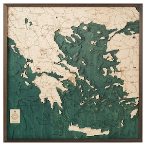 May include: A detailed wooden map of Greece with a teal blue color scheme. The map shows the coastline and islands of Greece, as well as the surrounding countries. The map is framed in a dark brown wood frame.