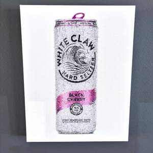 May include: A White Claw Black Cherry hard seltzer can rendered in a textured, beaded style. The design features a silver and white color palette with a prominent pink band across the center. The text reads White Claw Hard Seltzer Black Cherry.