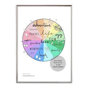 May include: A colourful wheel with the words "adventure", "dreamers", "travel", "explore", "friendship", "love", "life", "fun", "enjoy", "smile", "family", "memories", "joy", and "laugh" printed on it. The wheel is surrounded by stars and other small drawings. The image is framed in a silver plated frame. The frame is 3 inches by 5 inches or 7.5 cm by 12.5 cm.