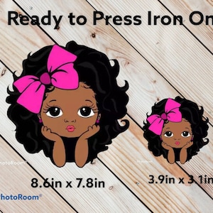 May include: Two iron-on transfers featuring a cartoon illustration of a young girl with dark curly hair, wearing a pink bow and earrings. The larger transfer measures 8.6 inches by 7.8 inches, and the smaller transfer measures 3.9 inches by 3.1 inches.  Ready to Press Iron On.