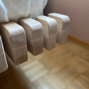 Könnte beinhalten: Nahaufnahme eines Bettrahmens aus Holz mit hellbrauner Oberfläche. Der Rahmen besteht aus einzelnen Latten, die miteinander verbunden sind, um ein stabiles und stilvolles Design zu schaffen.