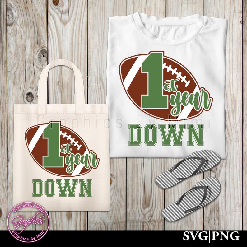 May include: A white tote bag and t-shirt featuring a brown and green football design. The football has the number "1" and the text "1st year down".