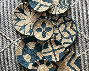 May include: A set of 11 round woven wall decor pieces in various geometric patterns. The pieces are made of natural materials and feature a blue and beige color scheme.