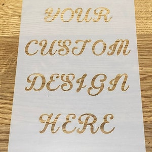 Peut inclure: Pochoir blanc avec les mots "YOUR CUSTOM DESIGN HERE" en écriture cursive dorée.