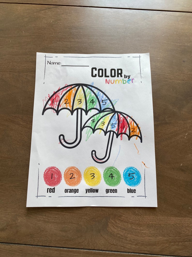 May include: Color by number activity sheet featuring two umbrellas with rainbow colors. The numbers 1 through 5 are written on the umbrellas, and the corresponding colors are shown below: red, orange, yellow, green, and blue.