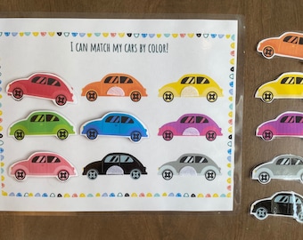 May include: A learning activity for children featuring a white card with the text "I can match my cars by color!" and nine colorful cars. There are nine additional cars on the right side of the image that can be matched to the cars on the card.