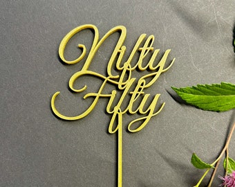 May include: Gold-colored cake topper with the words "Nifty Fifty" in a cursive font.