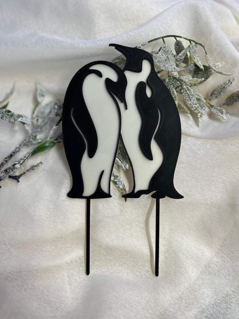 Elegant black and white penguin silhouette cake topper, featuring two penguins as a symbol of love and loyalty. Suitable for weddings, anniversaries, and romantic celebrations. Made with biodegradable PLA plastic.