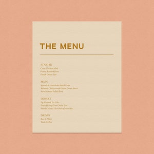May include: A beige menu with a gold border and the words "THE MENU" in gold lettering. The menu lists starter, main, dessert, and drinks options.