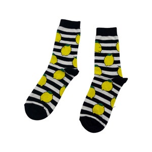 Könnte beinhalten: Ein Paar schwarz-weiß gestreifte Socken mit Zitronenmotiv.