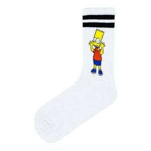 May include: White crew sock with a cartoon image of Bart Simpson. The sock has black stripes at the top. Bart is wearing a red shirt, blue shorts, and blue shoes. The sock is made of a soft material.